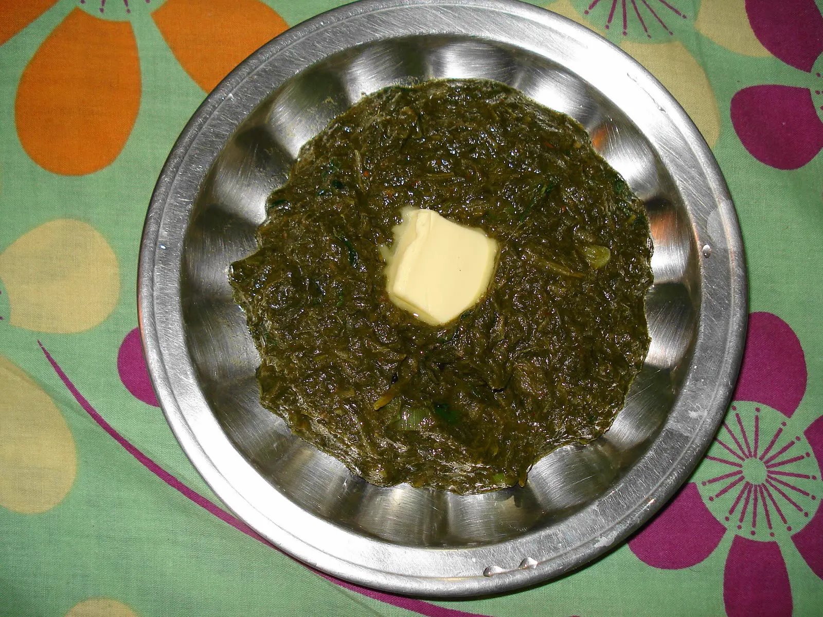 Saag with a knob of butter in a steel dish